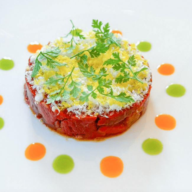 Tartare di scamone con guarnizioni di erbe fresche e salse colorate, servita su un piatto bianco al Ristorante Braceria.