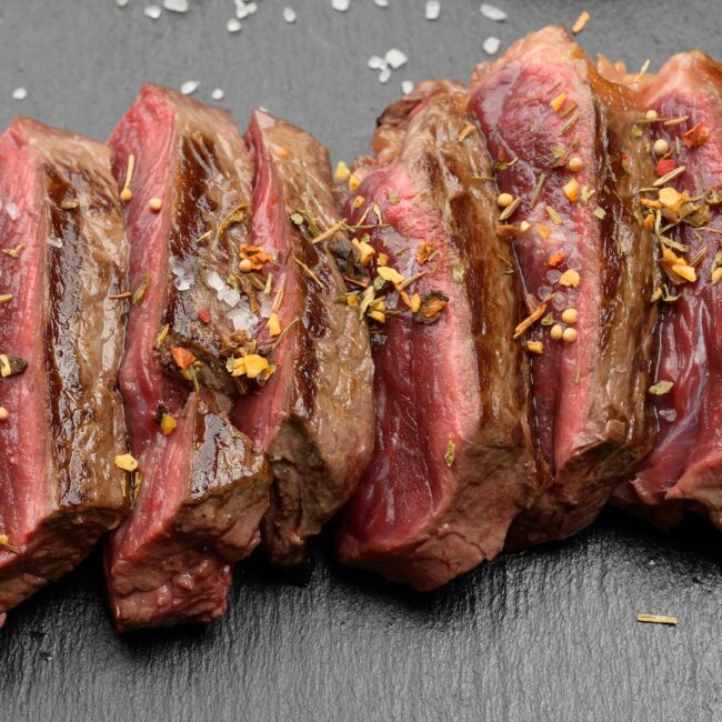 Deliziosa tagliata di manzo Sashi cucinata alla brace, accompagnata da spezie aromatiche e una spolverata di sale grosso